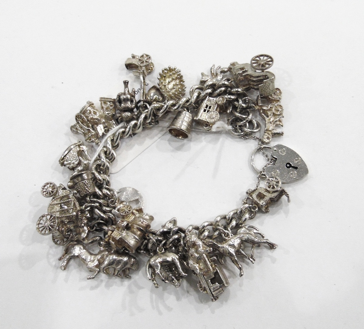 Heavy silver curb-link charm bracelet hung with numerous silver charms including articulated - Image 2 of 2