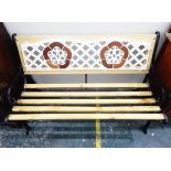 Slatted garden bench seat with decorative painted iron trellis panelled back,