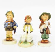 Three various Goebel Hummel figures including boy with pig in basket on his back,