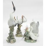 Pair of Lladro models of cranes standing amongst reeds encrusted with flowers,