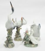 Pair of Lladro models of cranes standing amongst reeds encrusted with flowers,