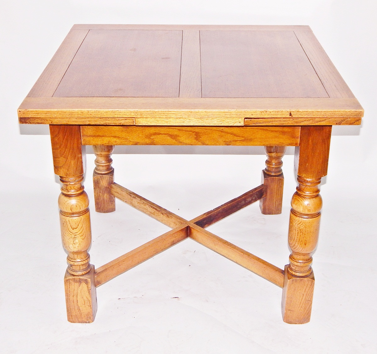 Circa 1930's oak-finish draw-leaf dining table on turned supports and cross-stretchers and five