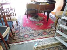 Eastern wool carpet, with central cream floral decorated medallion on a red ground,