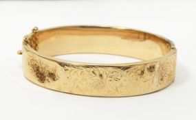 9ct gold hinged bangle with engraved decoration, 14g approx.