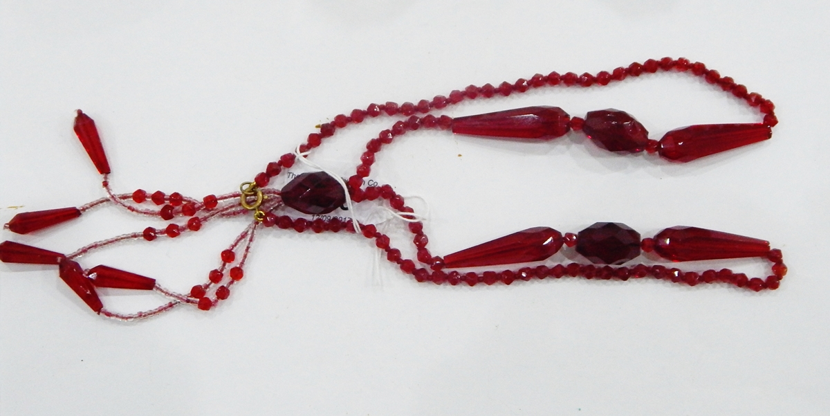 Vintage red glass bead necklace with faceted beads of varying shades of red and with central tassel