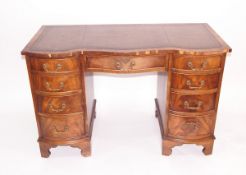 Reproduction mahogany veneered double-bowfront kneehole writing desk having tooled leather inset