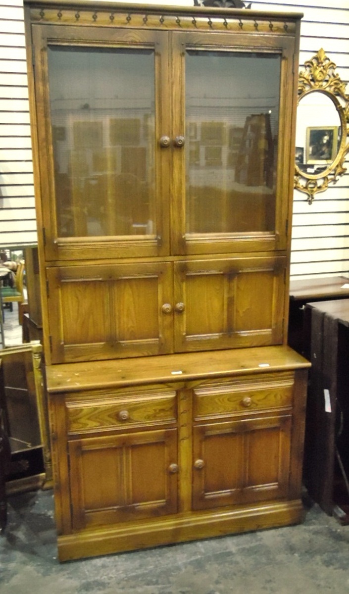 Modern oak dresser with pair of glazed panel doors enclosing shelves above two smaller drawers and