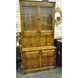 Modern oak dresser with pair of glazed panel doors enclosing shelves above two smaller drawers and