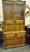 Modern oak dresser with pair of glazed panel doors enclosing shelves above two smaller drawers and