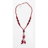 Vintage red glass bead necklace with faceted beads of varying shades of red and with central tassel