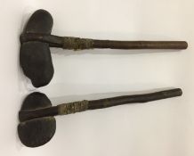 Pair Oceanic stone-head axe-type clubs bound to a wooden shaft with leather and reeds,