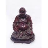 Early 20th century large carved hardwood figure of a seated laughing Buddha with bone teeth,