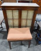 Mahogany glazed bookcase of doors enclosing two shelves, on turned supports,