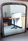 Overmantel mirror of rectangular form with arched top, the frame with ebonised and gilt decoration,