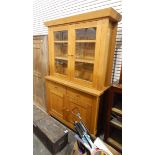 Modern pale oak dresser, the pair of glazed panelled doors enclosing shelves,