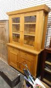 Modern pale oak dresser, the pair of glazed panelled doors enclosing shelves,