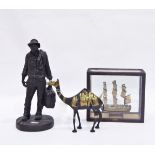 Bronze-effect model of a man carrying a suitcase,