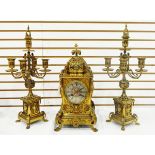 Brass clock garniture comprising a clock with circular engraved steel dial with Roman numerals,