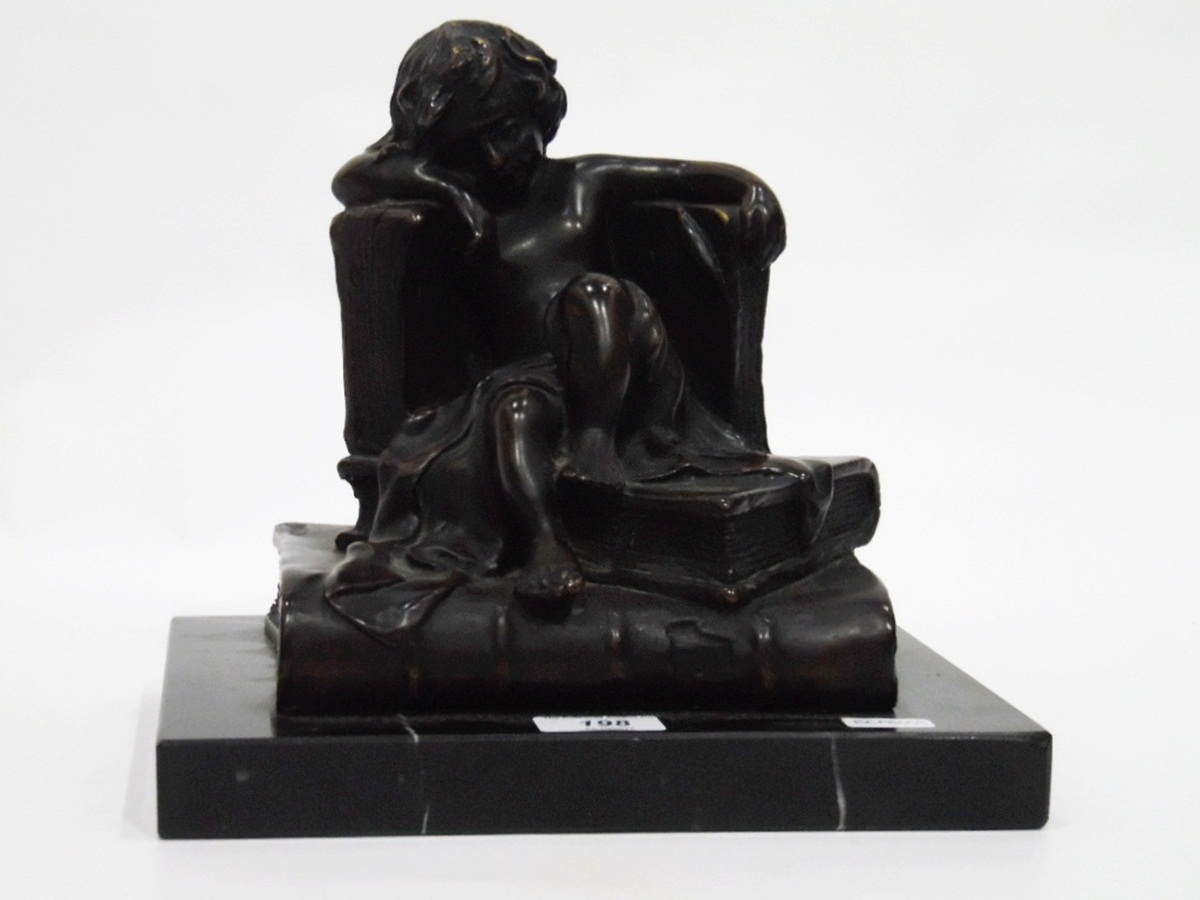 Art Deco style bronzed-effect sculpture of a child sitting on books, on a marbled base,