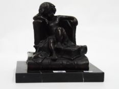 Art Deco style bronzed-effect sculpture of a child sitting on books, on a marbled base,