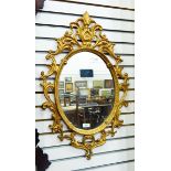 Gilt painted metal oval mirror, 74cm x 46cm approx.