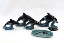 Four Poole pottery model dolphins,