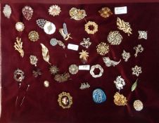 Various 20th century brooches to include a silver and enamel leaf-shaped brooch with diamante,