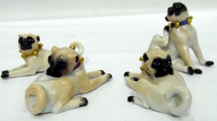 Set of four model pug dogs with blue cross-swords mark to base, the largest 6cm high approx.