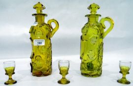 Pair of yellow glass decanters in relief with etched horses on shields,