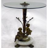 Circular glass-topped table on decorative brass pedestal with two putti to base and circular marble