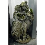 Composition stone garden ornament of lovers, raised on a circular plinth,