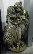 Composition stone garden ornament of lovers, raised on a circular plinth,