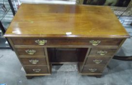 Reproduction mahogany kneehole desk having one frieze drawer over three short drawers and cupboard