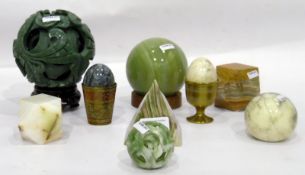 Green agate pyramid-shaped paperweight, a carved green soapstone puzzle ball on stand,