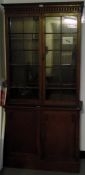 Edwardian oak bookcase on cupboard having flat moulded cornice over two astragal-glazed doors and