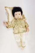 Franklin Heirloom doll of a Oriental child in traditional dress, fixed brown eyes and painted mouth,