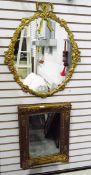 Modern gilt-coloured oval framed mirror with bow and floral decoration,