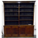 Stained wood library bookcase having five-tier open upper section and on a cupboard base,