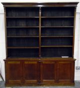 Stained wood library bookcase having five-tier open upper section and on a cupboard base,
