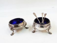 Pair of silver salts, each circular on stepped pad feet with blue glass liners,