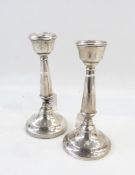 Pair of George V silver candlesticks of tapering cylindrical form, on a raised circular foot,