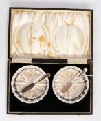 Pair of cut glass butter dishes, circular, each with silver butter knife,