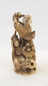 Japanese carved ivory figure group of man selling peaches to lady seated with fan,