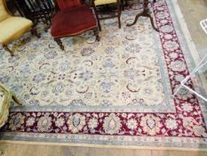 Persian-style wool carpet, the cream ground allover floral decorated with red ground herati border,