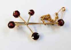 Gold-coloured metal and garnet abstract brooch