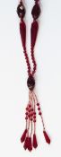 Vintage red glass bead necklace with faceted beads of varying shades of red and with central tassel