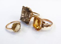 Two gold citrine set dress rings and another larger set with smoky quartz