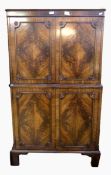 Reproduction mahogany drinks cupboard with panelled cupboard above and below, on bracket feet,