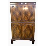 Reproduction mahogany drinks cupboard with panelled cupboard above and below, on bracket feet,