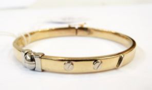 Gold and white coloured metal hollow bangle in the style of Cartier,